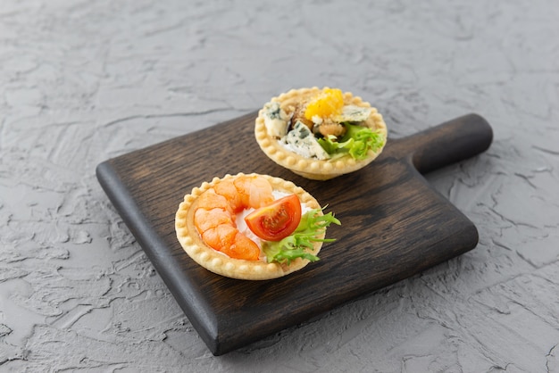 Tartaletas en una tabla de madera sobre un fondo gris