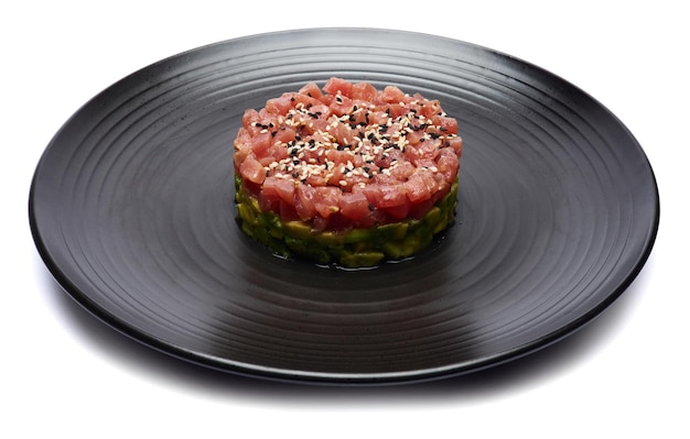 Foto tartar de atum e abacate num prato de cerâmica escura