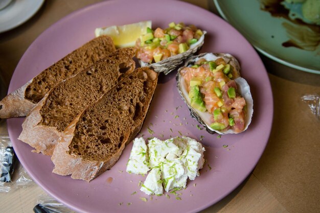 Foto tartar de salmão com torradas e queijo num prato. foto de alta qualidade