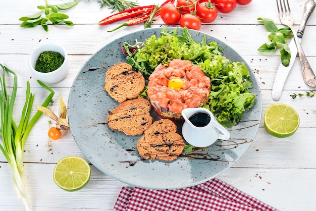 Tartar con salmón y aguacate Sobre un fondo de madera Vista superior Espacio de copia