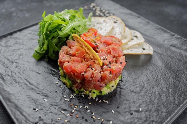 Tartar de salmón con aguacate sobre fondo negro