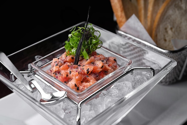 Tartar de salmón en hielo con tostadas enfoque selectivo