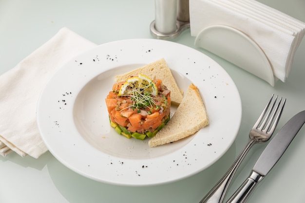 Tartar de salmón en una placa blanca.