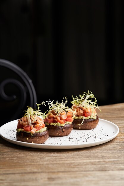 Tartar de salmón con salsa de guacamole. Tostadas con guacamole y salmón en plato blanco. Mesa de comida de restaurante de lujo