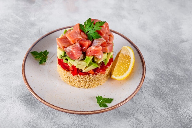 Tartar de salmón con tomate, aguacate y quinua en un plato