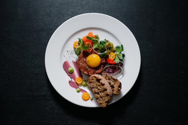 Tartar de ternera con guarnición de salsas a las hierbas y servido con picatostes