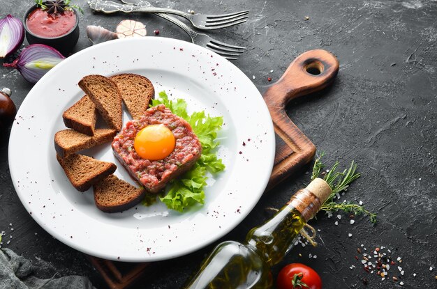 Tartar de ternera con yema de huevo y pan negro Vista superior Espacio libre para el texto