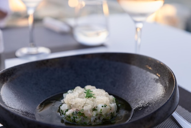 Tártaro de robalo com salsa de gelo de limão e cebolinha, foco seletivo