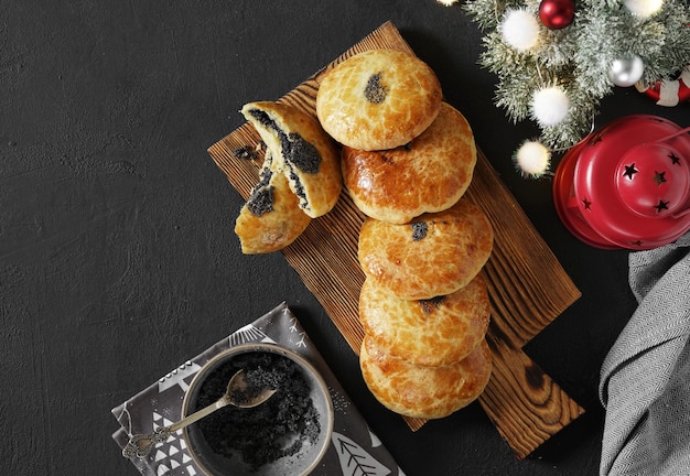 Tartas austriacas tradicionales de Navidad Mohnzelten con semillas de amapola rellenas en una mesa oscura con árbol de Navidad y juguetes en el espacio de copia de la vista superior de fondo