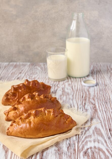 Tartas caseras y leche en la mesa de madera, cerrar