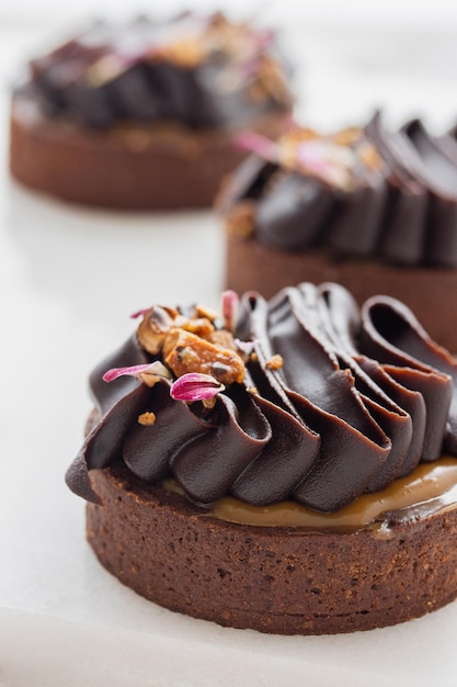 Tartas de chocolate decoradas con ganache de chocolate oscuro sobre un fondo blanco