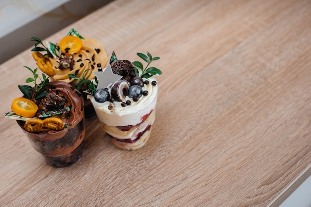 Tartas de chocolate y vainilla con frutas en vasos