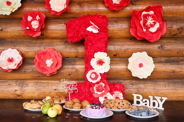 Tartas de cumpleaños y muffins con carteles de saludo de madera en la pared rústica. Madera cantar con letras feliz cumpleaños, bebé y dulces de vacaciones.