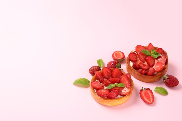 Tartas de fresa sobre fondo rosa, espacio para texto.