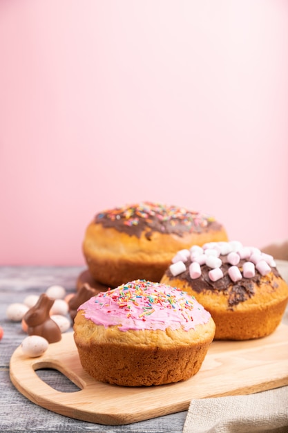 Tartas de Pascua caseras esmaltadas y decoradas sobre una superficie de madera gris y textiles de lino. Vista lateral, enfoque selectivo, copia espacio.