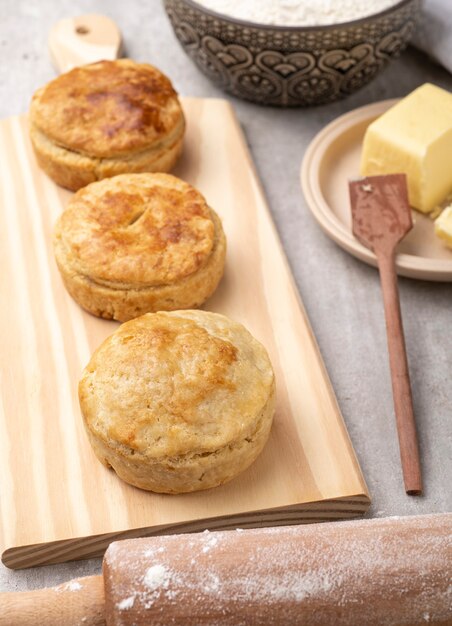 Tartas de pollo caseras sobre tabla de madera con ingredientes.