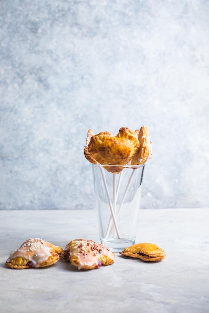 Tartas pop de corazón de fresa, tomadas desde arriba sobre un fondo de hormigón. Sabroso pastel tostado