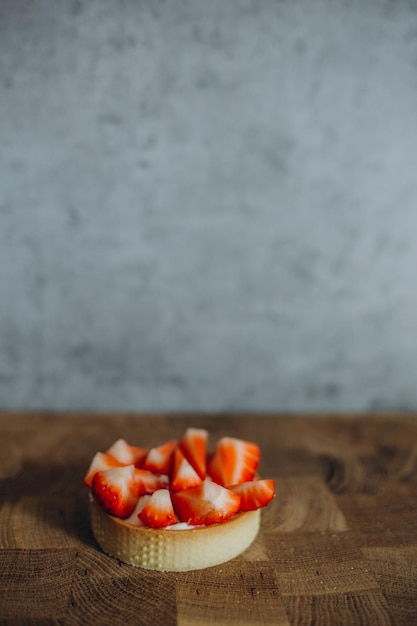 Tartas de queso crema de vainilla y fresa sobre fondo gris claro