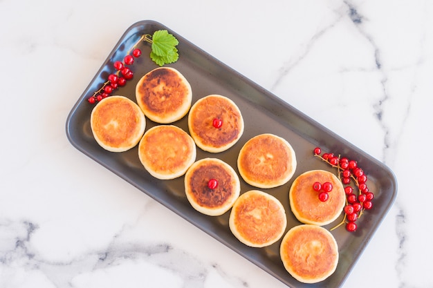 Tartas de queso desayuno o postre panqueques de requesón de cuajada syrniki. vista superior de comida saludable