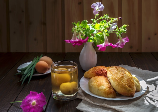 Tartas y un ramo de petunias en una mesa de madera.