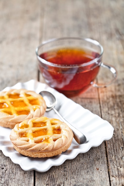 Tartas recién horneadas con mermelada o mermelada de albaricoque en un plato de cerámica blanca.