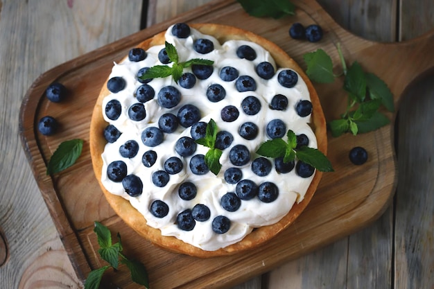 Tarte com mirtilos e creme de manteiga branco. Sobremesa de frutas de verão.