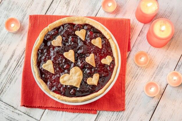 Tarte de geleia de cereja decorada com corações e velas acesas