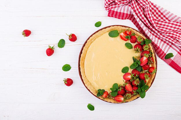 Tarte mit Erdbeeren und Schlagsahne, dekoriert mit Minzblättern