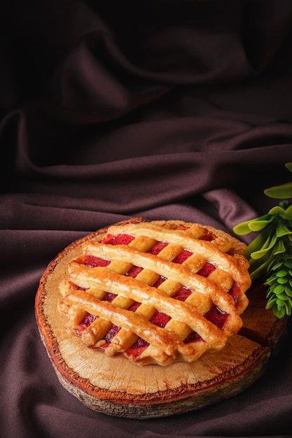 Tartelete ou torta recheada com geléia de morango deliciosa caseira em uma madeira marrom e pano para um lanche