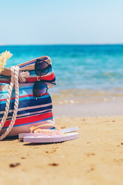 Tasche und Sachen zum Entspannen am Meeresstrand. Selektiver Fokus. Natur.