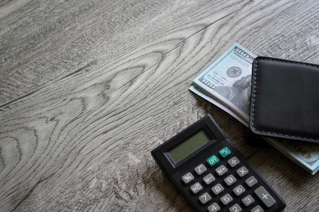 Taschenrechner und Geld auf Holztisch mit Kopierbereich Geschäfts- und Finanzkonzept