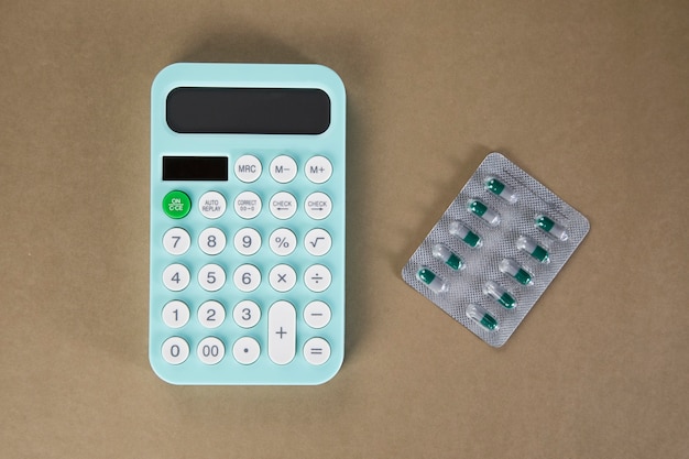 Taschenrechner und Pillen auf dem Tisch. Konzept zur Zählung der Gesundheitsausgaben. Pille einkaufen zählen