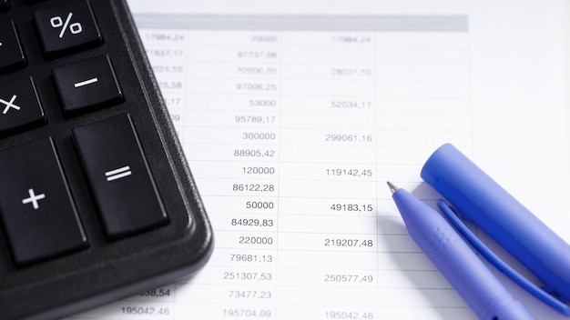 Taschenrechner und Stift auf weißem Papier mit Zahlen. Geschäfts- und Finanzbuchhaltungskonzept.