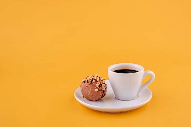 Tasse Americano-Kaffee und Makronen auf gelbem Hintergrund Platz für Text