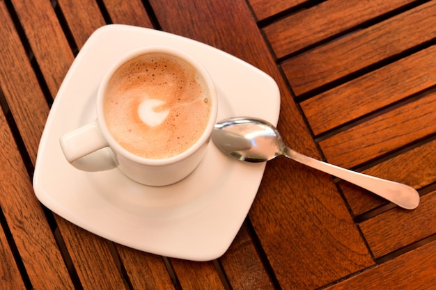 Tasse Cappuccino auf einem Holztisch.