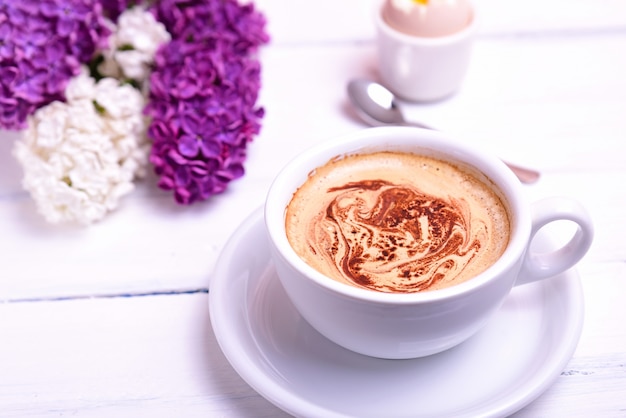 Tasse Cappuccino auf einem weißen Holztisch