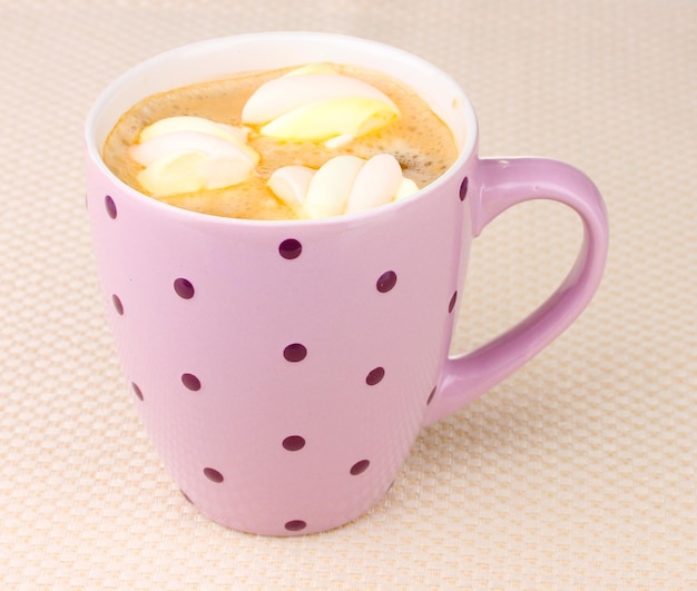 Tasse Cappuccino mit Marshmallows auf beigem Hintergrund