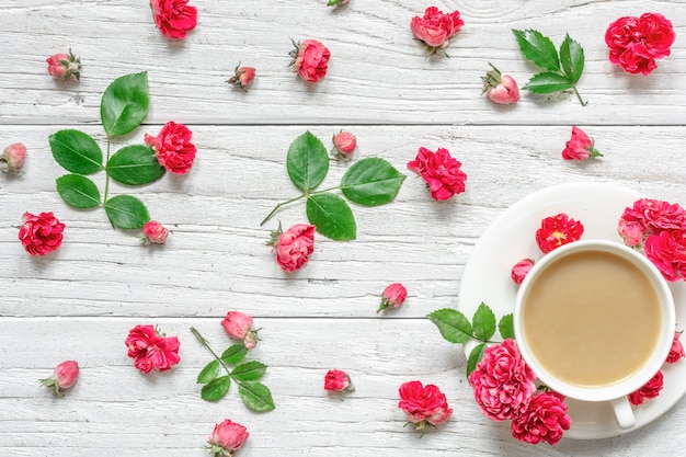 Tasse Cappuccino oder Kaffee mit Milch mit Blumenzusammensetzung gemacht von den Rosarosenblumen