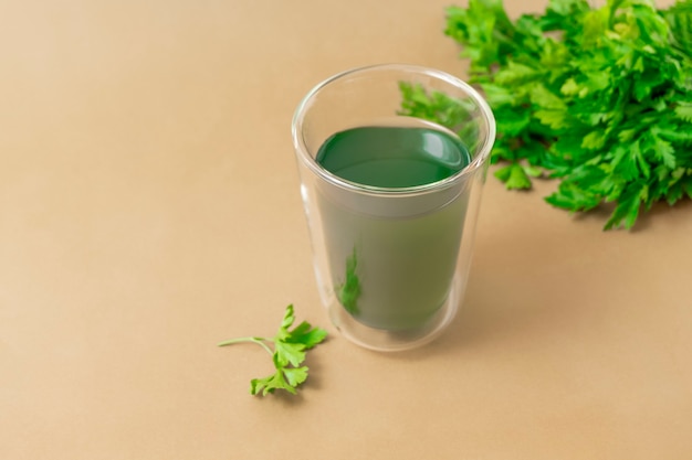 Tasse Chlorophyllwasser auf hellbeigem Hintergrund mit Kopierraum