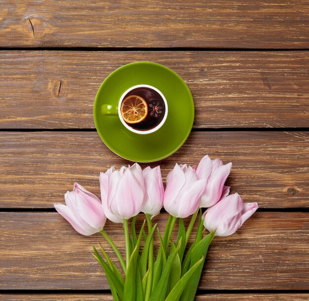 Tasse englischen Tees mit Frühlingstulpen auf Holz