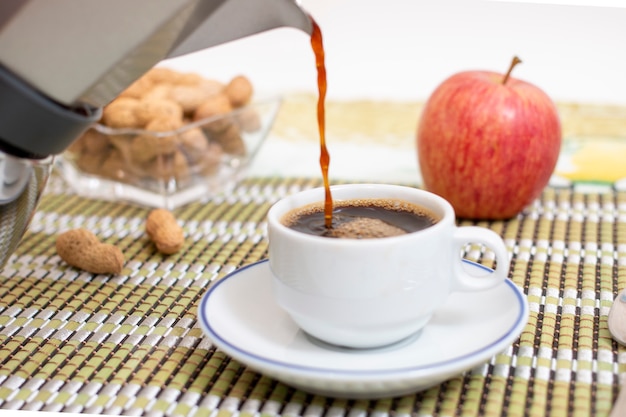 Tasse Expresso-Kaffee mit Erdnüssen und Obst