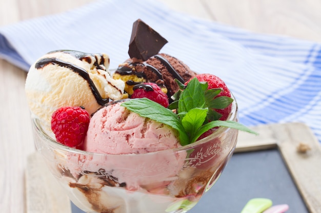 Tasse frisches gemischtes Eis mit Beeren und Schokolade Nahaufnahme