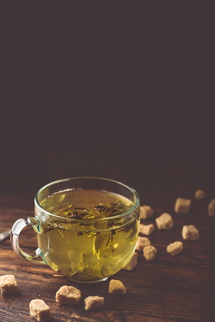 Tasse grüner Tee mit braunem Teezucker