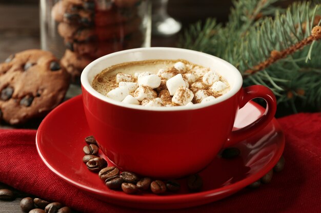 Tasse heiße Schokolade mit Marshmallows, Tannenzweig auf Holztisch