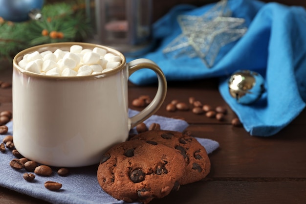Tasse heiße Schokolade mit Marshmallows, Tannenzweig auf Holzuntergrund