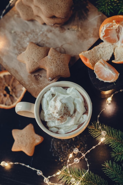 Tasse heiße Schokolade mit Sahne auf dem Hintergrund von Lebkuchen, Weihnachtsdekor