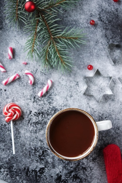 Tasse heiße Schokolade oder Kakao und eine Auswahl an süßen Weihnachtsbonbons Gemütliches Winterurlaubsdekor und selektiver Fokus der Tannenbaum-Draufsicht