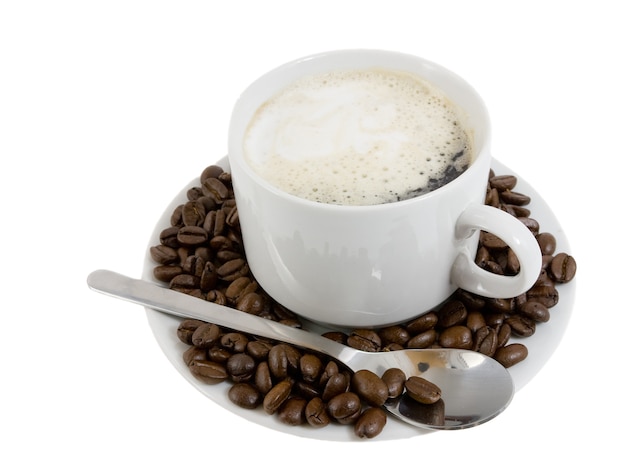 Tasse heißen Kaffee auf einem weißen Plateau und Kaffeekörner. Isoliert.