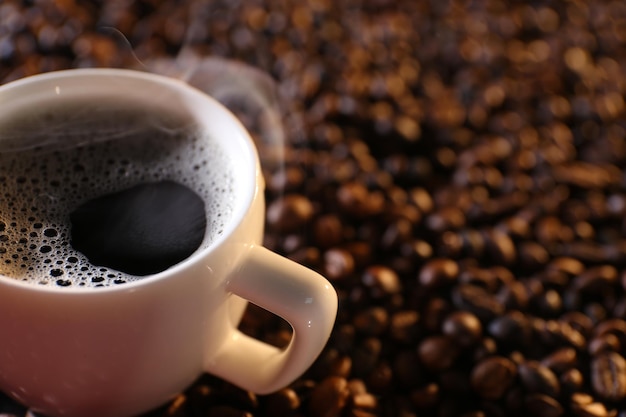 Tasse heißen Kaffee auf Kaffeebohnen Hintergrund