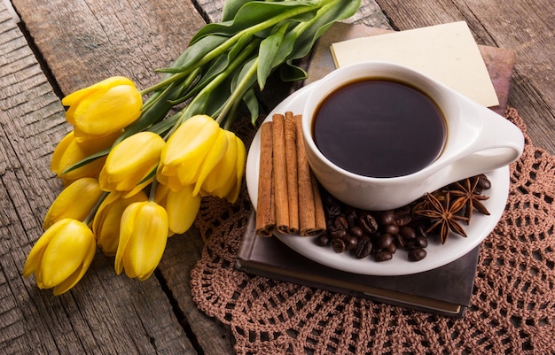 Tasse heißen Kaffee und gelbe Tulpen